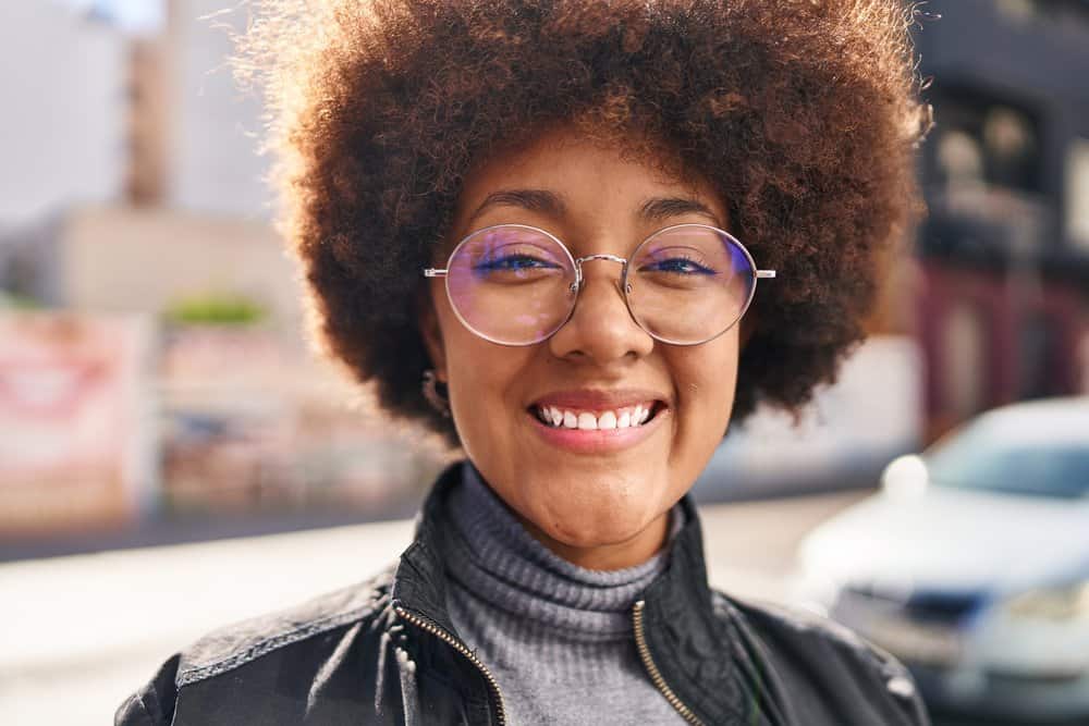 A cute African American woman with fine curly hair styled with a curl cream and other light-weight products.