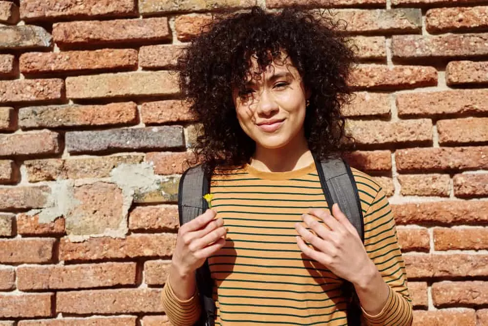 How to Clarify Curly Hair at Home: DIY Clarifying Guide 11 A cheerful African American female with clean hair that was washed with the perfect clarifying shampoo.