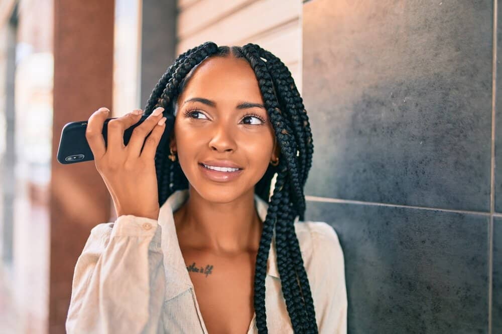 Young African American college student listening to the Curl Centric podcast on her smartphone in Atlanta, GA.