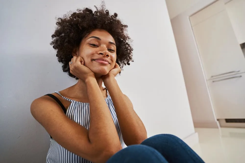 Curly Girl Method: How to Guide, CG Method Steps & Products 7 African American female that's following the curly hair method keeps their hair curly by avoiding hot tools.