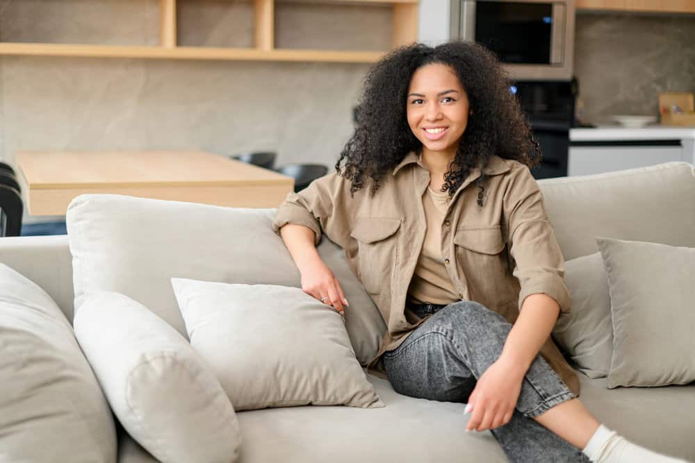 African-American woman with healthy hair after treating her precious locks with natural oils to reduce hair breakage.