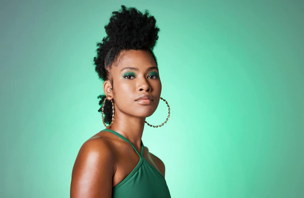 A beautiful black woman wearing a popular protective hairstyle to reduce hair breakage on thick, dense hair stands.