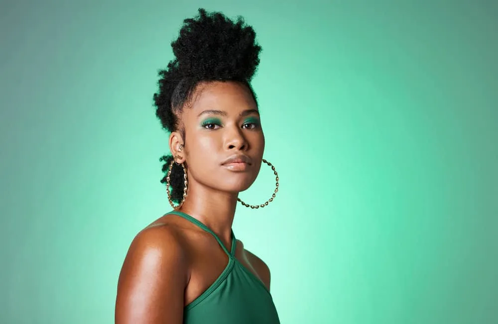 Protective Hairstyles for 4C Hair: 8 Low Manipulation Styles 1 A beautiful black woman wearing a popular protective hairstyle to reduce hair breakage on thick, dense hair stands.
