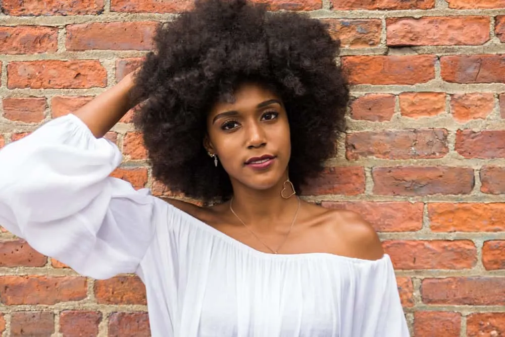 How to Wash 4B Hair: Detailed Step-by-Step Wash Day Routine 5 A cute black girl after using a deep conditioner on clean, soaking-wet hair to retain moisture before drying her curls.