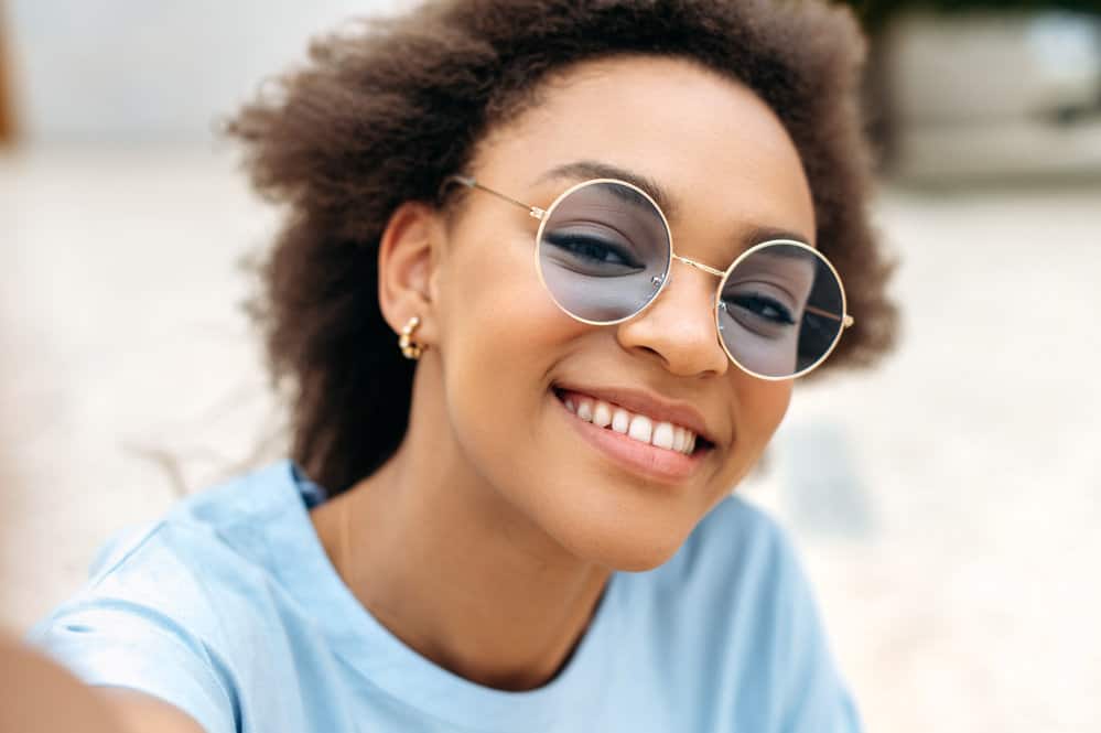 A trendy black girl with oily hair regularly detoxed with baking soda and styled with argan oil to avoid dry hair strands.