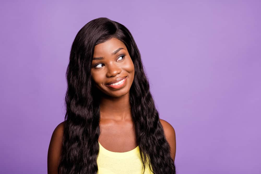 African American female letting her chemically-processed sew-in, glueless wig flow freely in the wind.