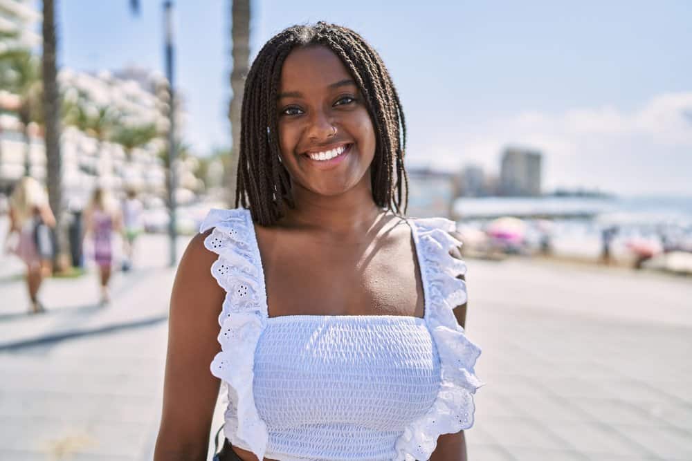 A black woman wearing her hair "natural" with confidence as her natural curls are in poetic justice style braids.