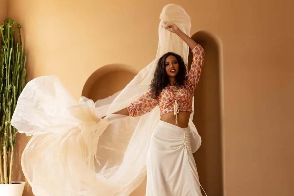 Ayurvedic Hair Growth: How to Use Ayurveda Hair Oil & Herbs 11 A black woman that's an ayurvedic practitioner uses ayurvedic treatments to provide her hair follicles nourishment.
