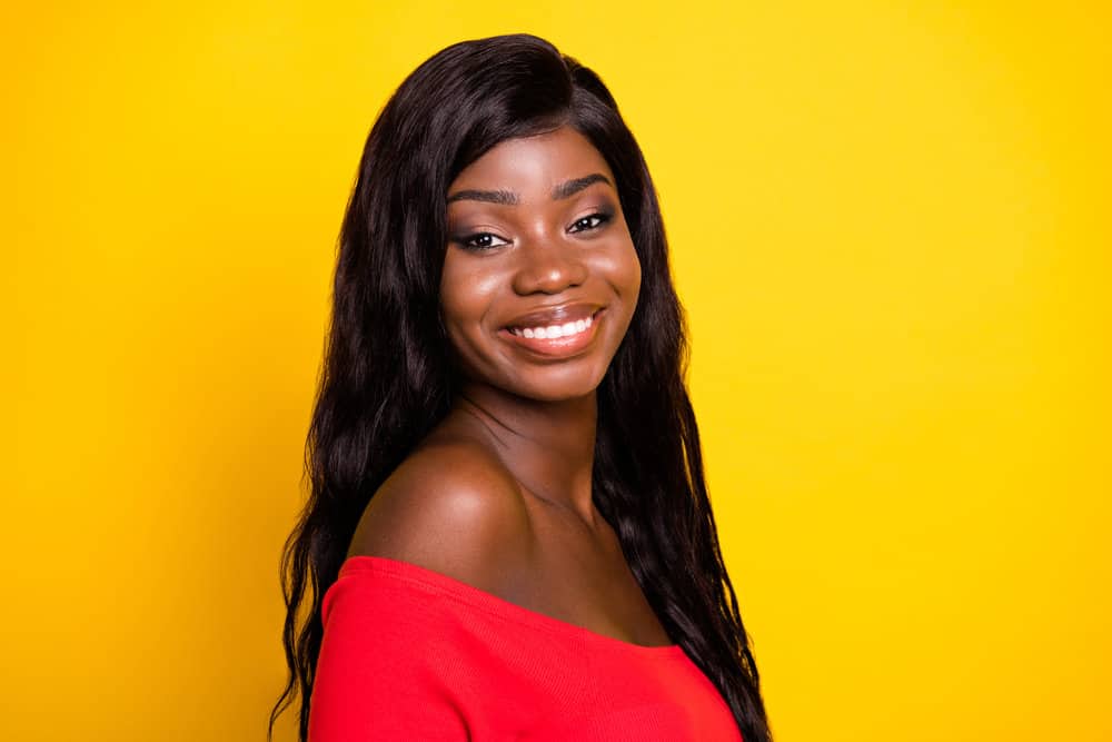 A cute young black girl wearing a quality wig with a swiss lace wig cap and baby hair styled with a toothbrush.