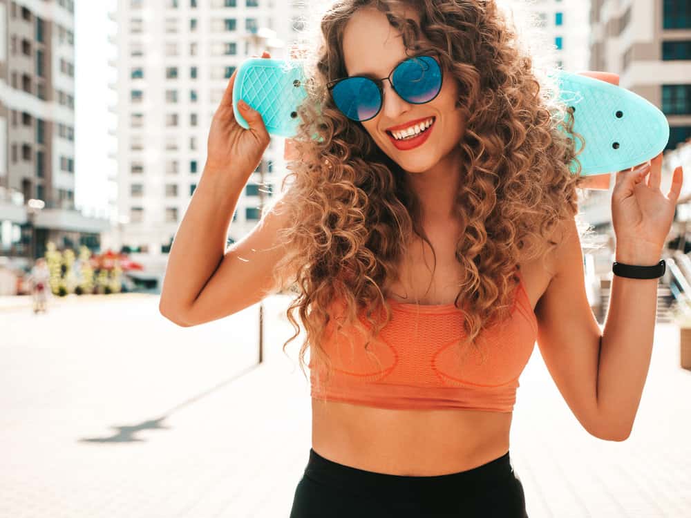 A cute white girl with towel-dried hair used a permanent liquid toner to remove cool tones from her yellow hair.