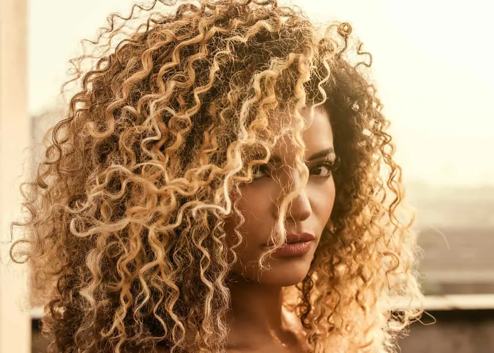 Wella T28 Before and After on Dark, Orange, Yellow Hair & More 1 A black girl with towel-dried hair used a pale ash blonde permanent liquid toner on her unwanted orange tones.