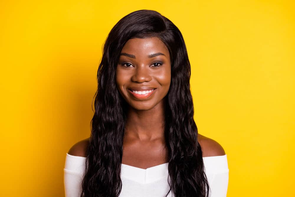 A cute black girl wearing a high-density wig made of fine hair strands and medium hair thickness.