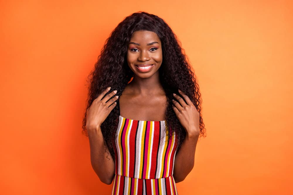 A young black girl with an authentic and cheerful look dons a lace wig with medium-density hair texture and fine hair.