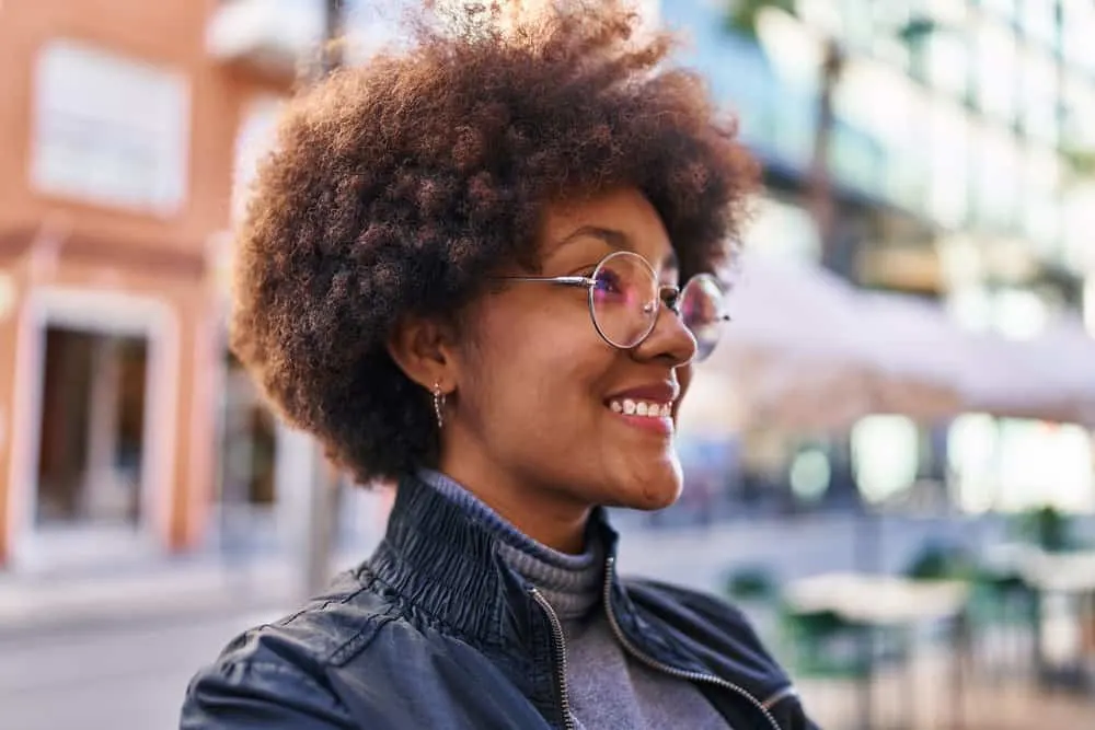 How to Care for Low-Density Curly Hair: DIY Step-by-Step 2 A confident black female with thin curly hair styled with the Curly Girl Method using Ouidad Climate Control Gel.