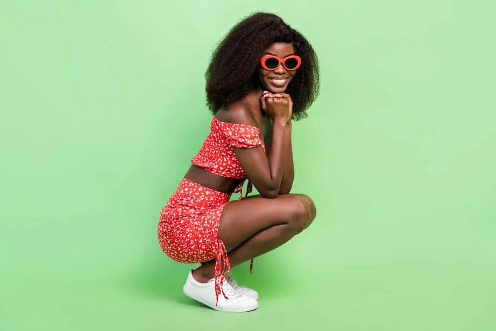 150% vs. 180% Density Curly Wig: Is 180 Density Better Than 150? 9 A stylish black female with a curly hair texture is wearing a medium-light density wig with natural-looking hair strands.