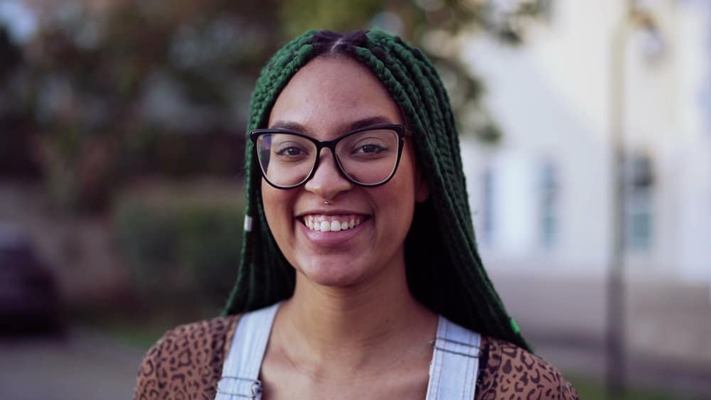 A young black woman with tight braids treated her braided hair follicles with an apple cider vinegar rinse.