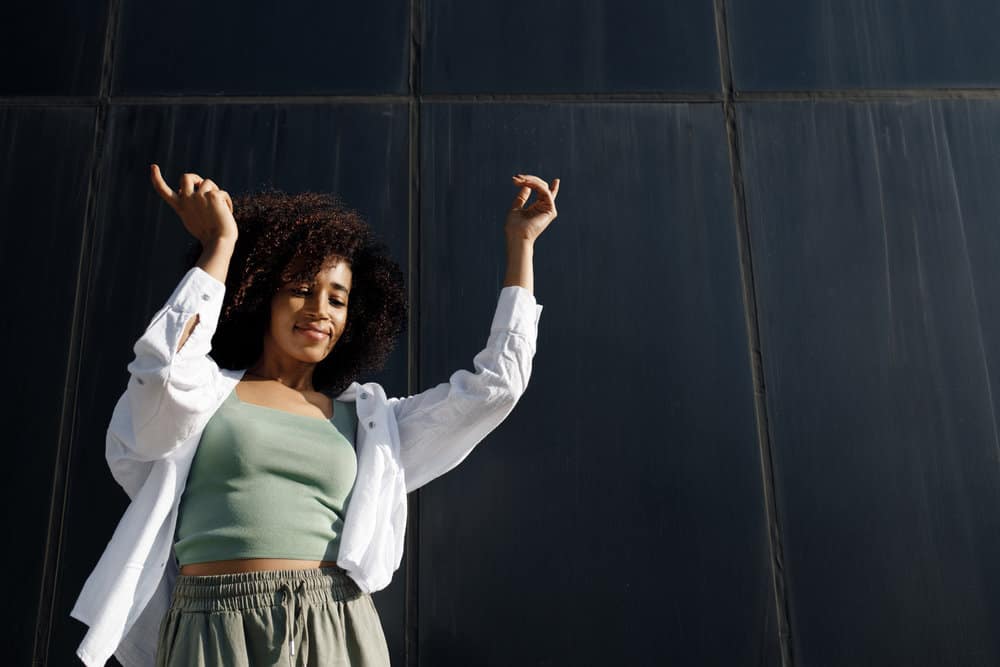 A black lady dancing outdoors who's wearing her hair naturally has a type 4 curl pattern and a 4A curly type.