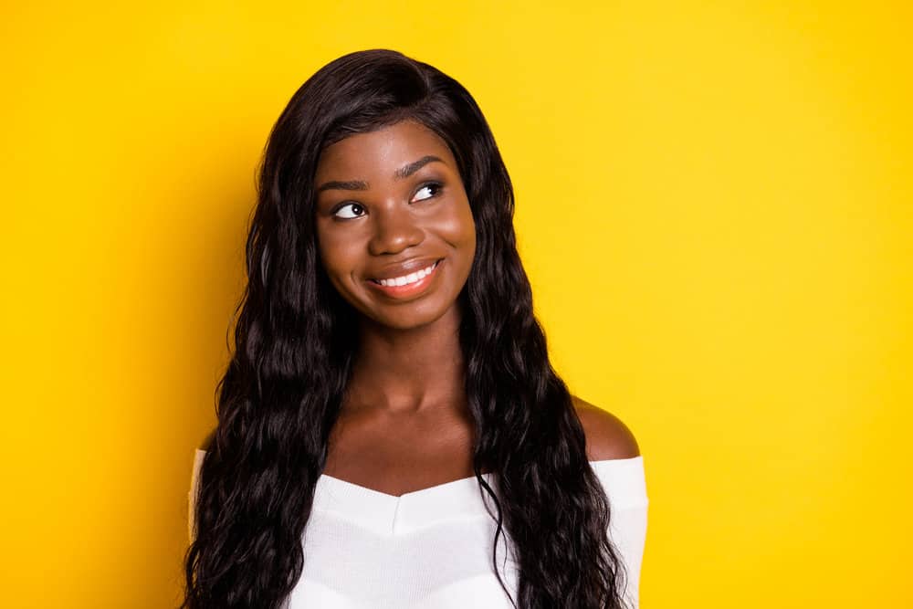 African American female wearing a lace wig with natural hair density looks very similar to human hair wigs.