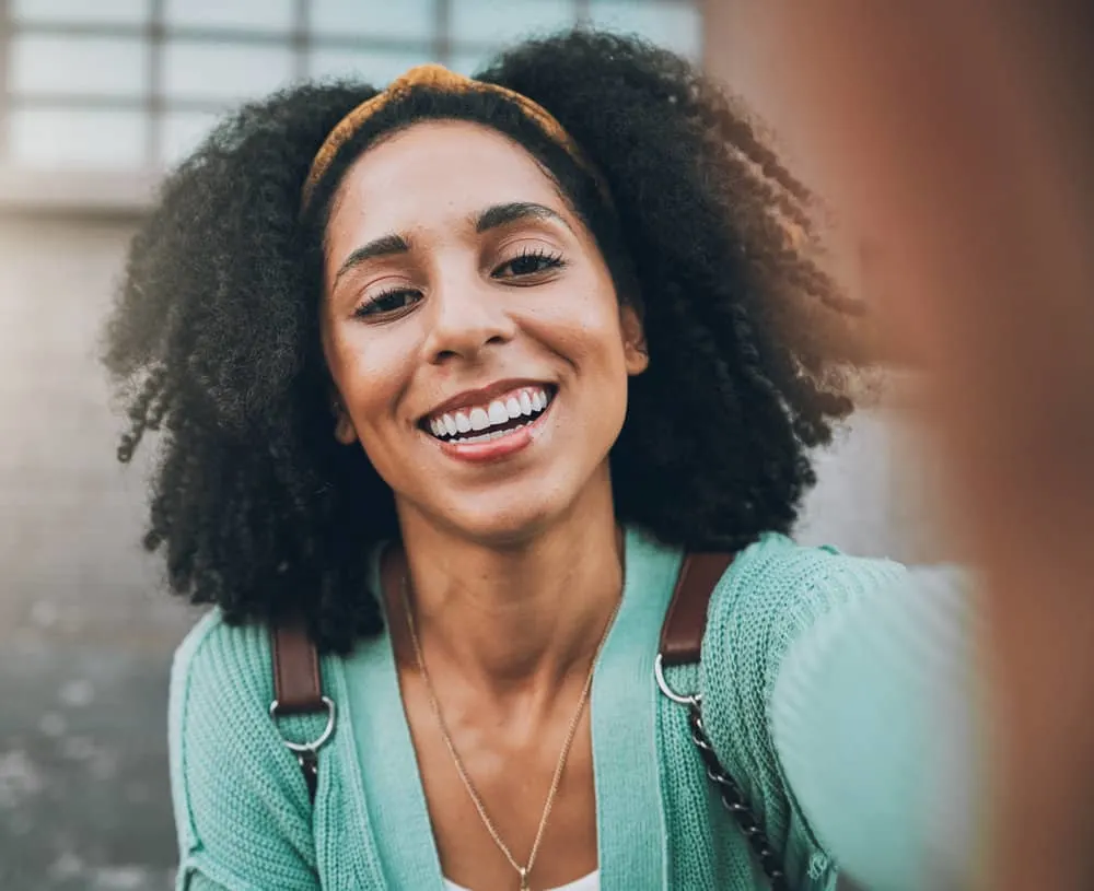 A beautiful African American female doesn't strip natural oils from her hair by using a traditional hair washing routine.