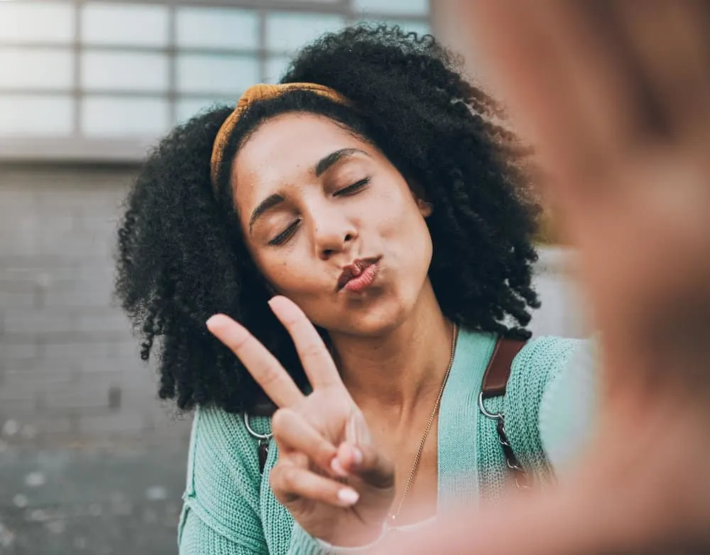 Co-Washing Hair Instead of Shampooing: DIY Step-by-Step 9 African female with beautiful natural curls uses a co-wash regularly to maintain her hair's natural moisture levels.