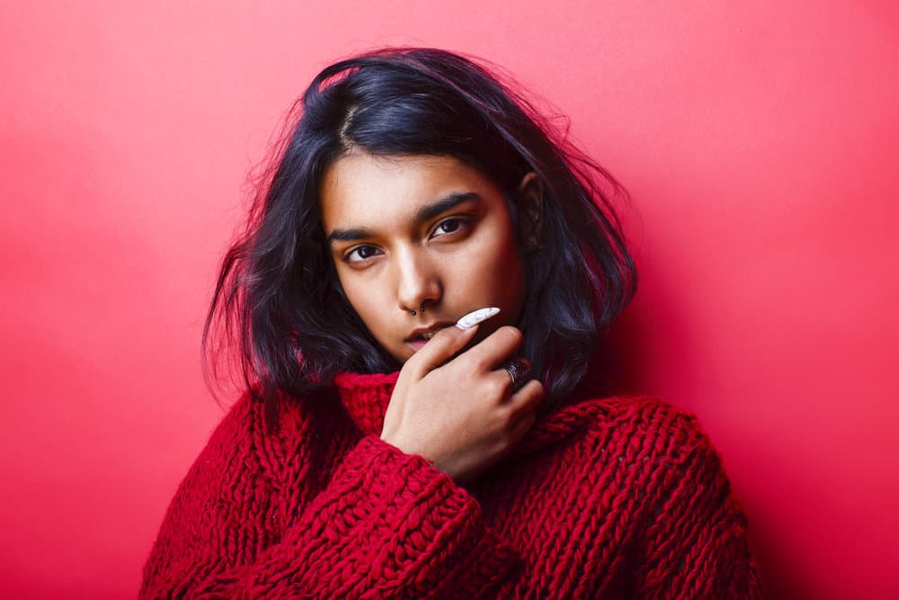 A young, pretty Indian girl with silky hair used natural hair oils, like coconut oil, to encourage healthy hair growth.