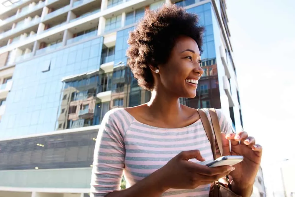 A black girl with short hair showed off her curl pattern while reading about how to take care of her new texture.