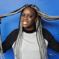 A black girl with black and blonde braiding hair extensions experiencing an allergic reaction from the dirty hair.