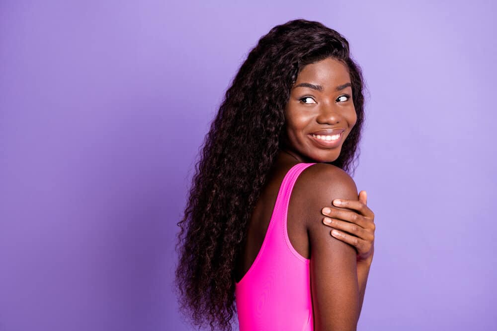 A charming African American female wearing a lace front wig with her baby hair styled normally around the lace part.