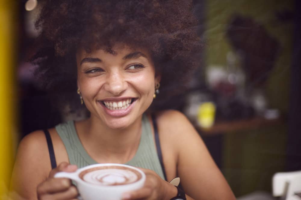 A black girl with curly hair used a regular scalp massage to reduce hair thinning and increase healthy blood flow.