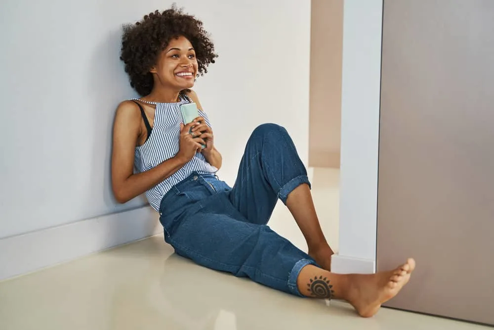 Curly Girl Method: How to Guide, CG Method Steps & Products 16 A beautiful young black female keeps her hair healthy by using the CG method on defined curls.