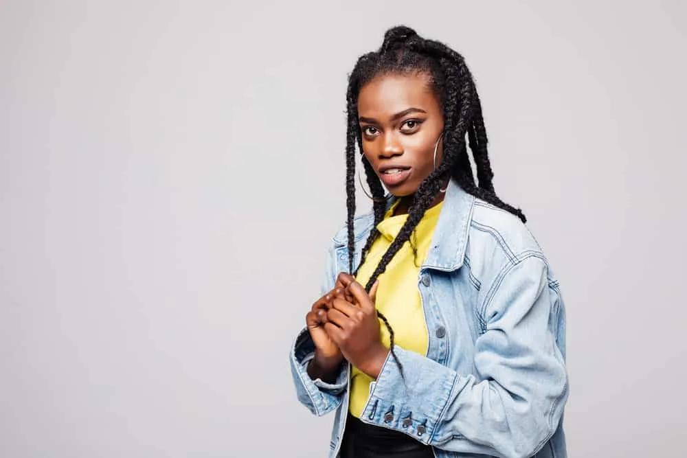 An African American female is wearing a basic braid hairstyle with a double French braid setup.