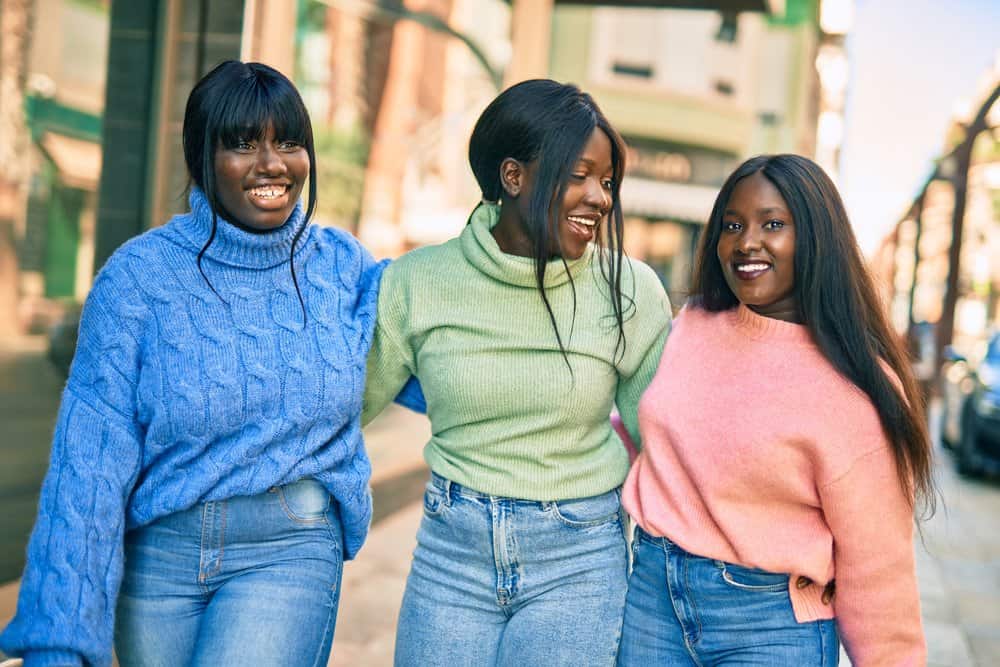 Three African ladies wearing lace front synthetic hair strands on a cool winter day.