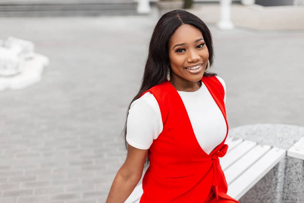 A fashionable black girl with a completely pre-plucked hairline is wearing a wig with a natural finish.