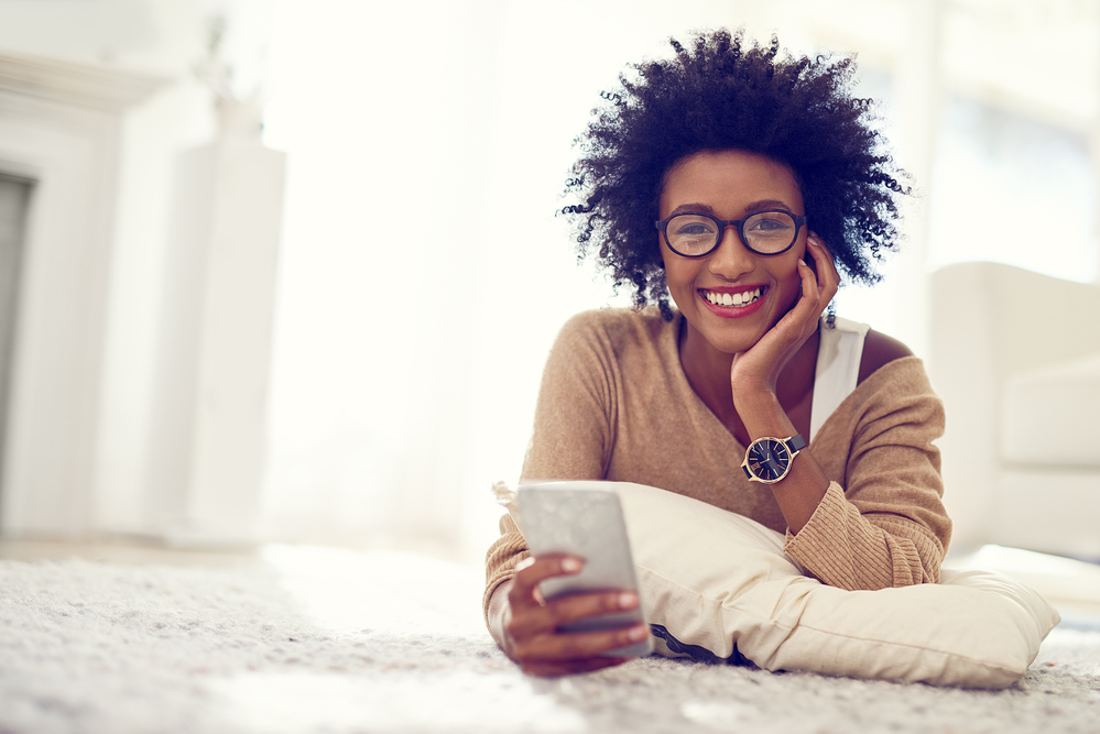 An African American female researching how to fix frizzy hair damaged with heat styling tools.