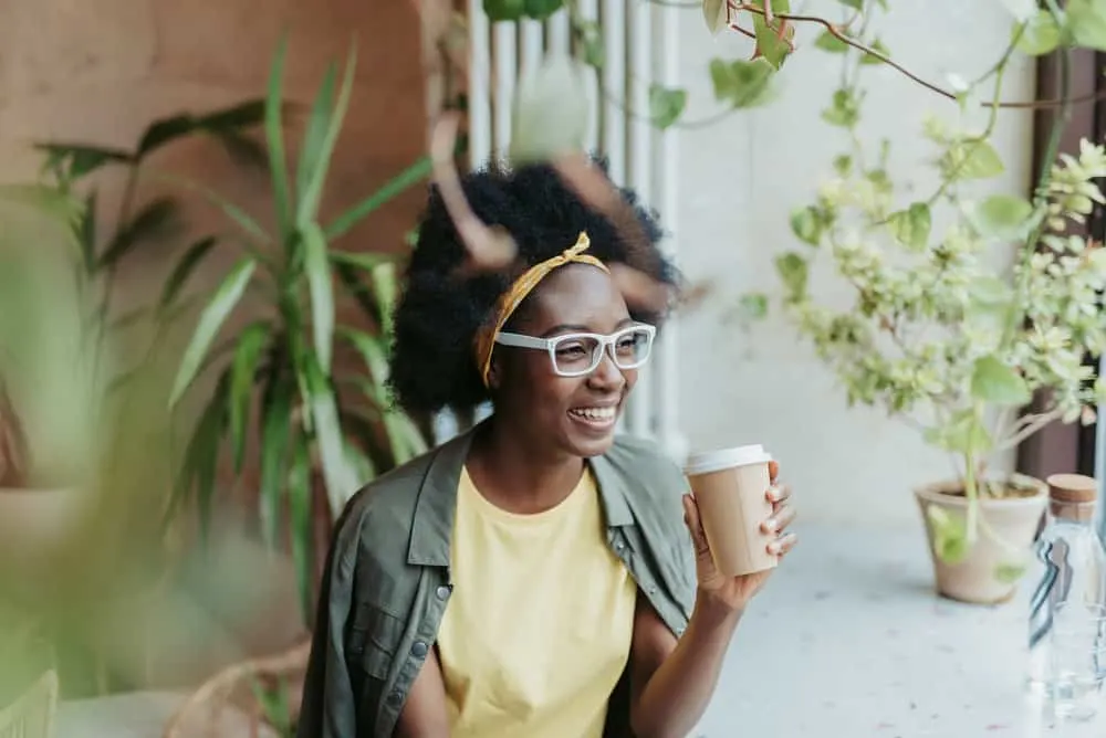 4B vs. 4C Hair: Differences, Characteristics & Best Products 10 A young African American female with a 4C hair pattern showing off her curls after recently removing box braids.