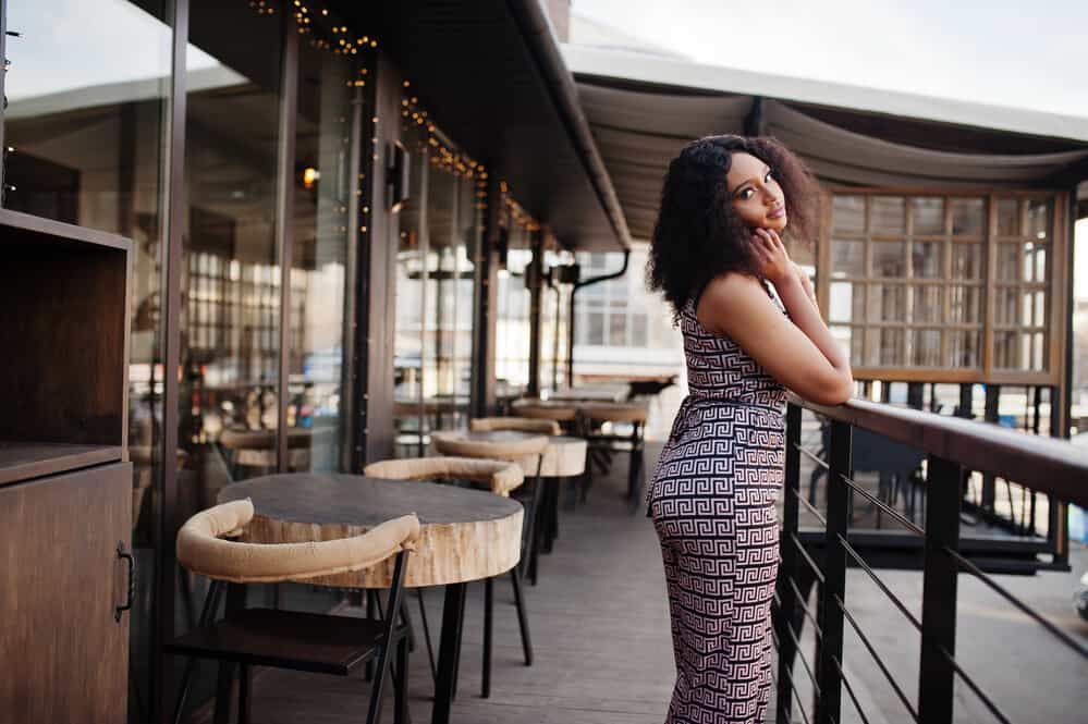 Elegant African American woman with curly hair wearing a pixie-cut wig.