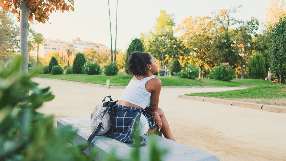 A cute black girl that is vitamin deficient uses clinically proven prenatal vitamins to aid hair growth goals.