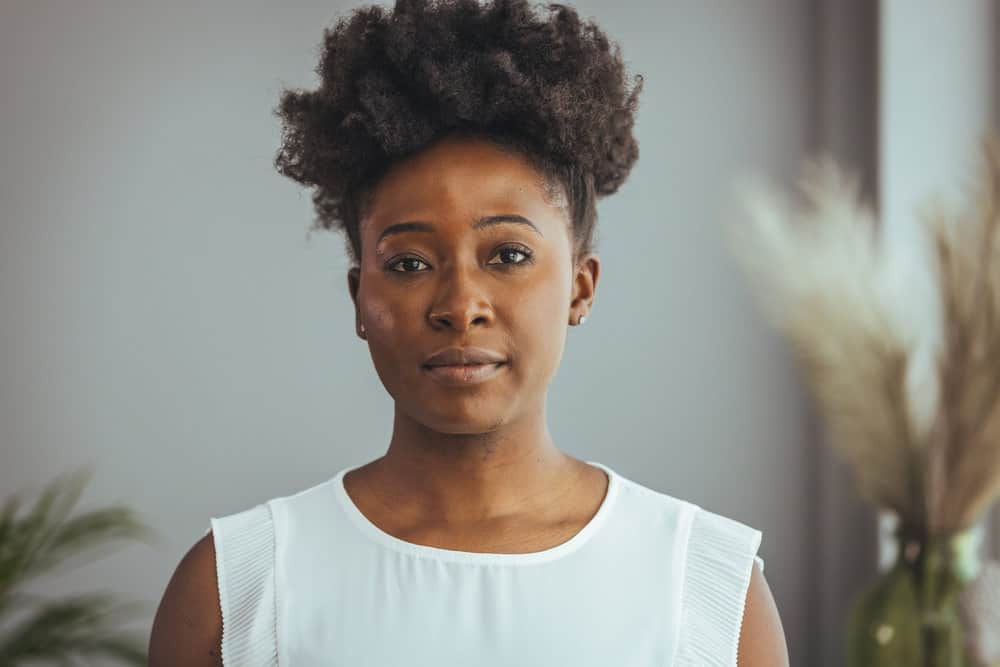 A professional black lady is looking stretch natural hair during her wash days to measure hair growth.