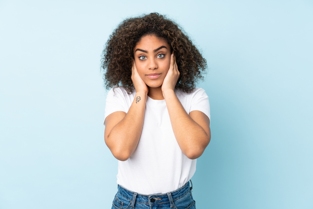 A black woman with naturally curly hair styled with tea tree oil and rosemary essential oil.