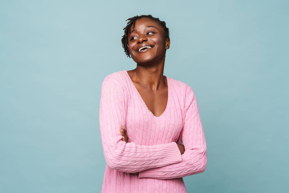 An African American female with 4B hair extensions ("fake hair") to make her thinning locs fuller and thicker.