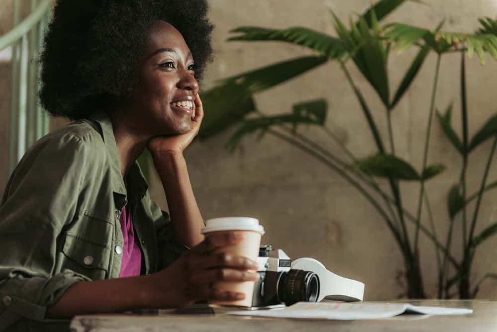 A beautiful American lady with an afro hairstyle keeps her hair moisturized with vitamin E to encourage length retention.