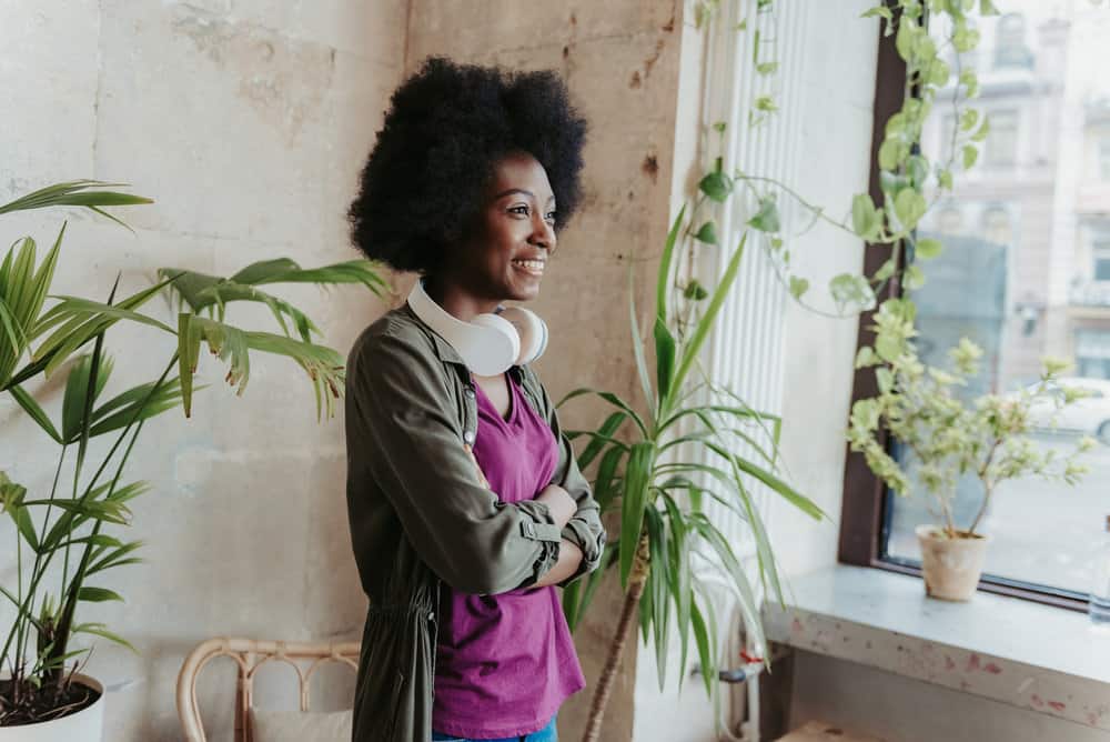 A black female with dry hair on dense and tight coils uses leave-in conditioners to retain moisture.