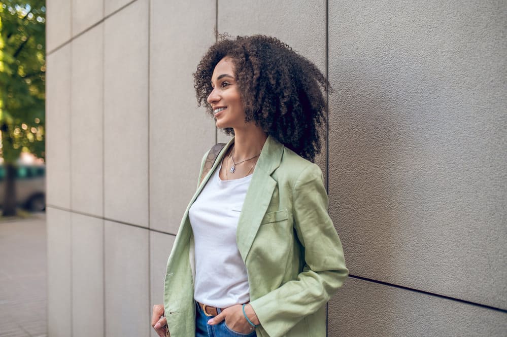 A beautiful black woman uses a natural hair growth oil to increase blood circulation and hair regrowth.