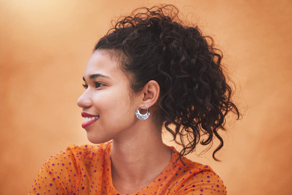 A cute black lady realizes her hair strand contracts after using bone marrow oil on her hair.