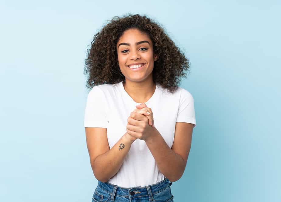 An African American female with naturally curly drab hair strands and oily dandruff.