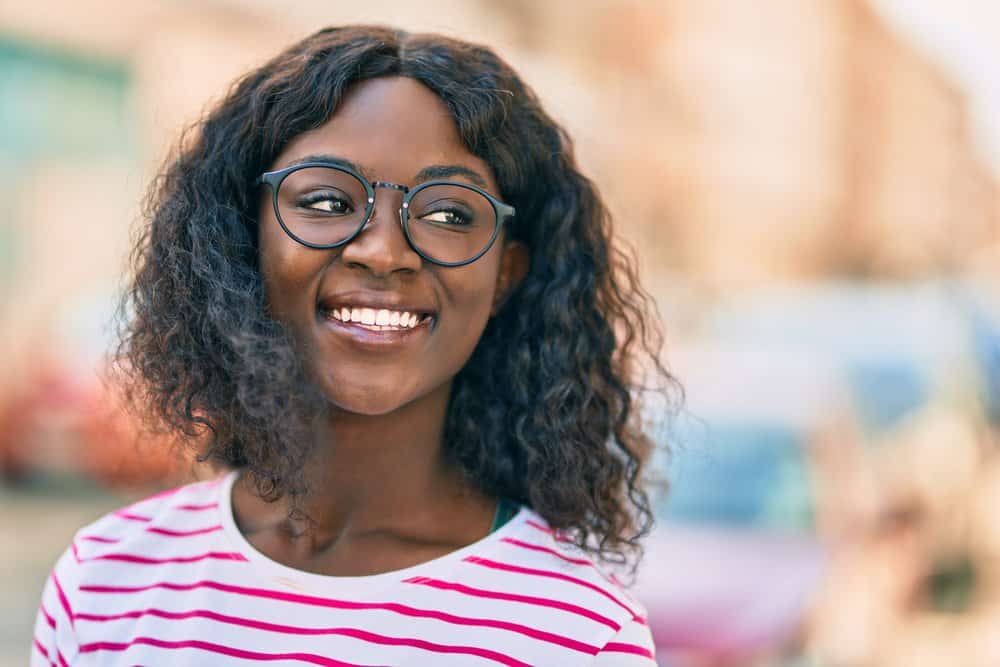 A black girl with fine hair wearing a lace wig cap with different hair densities attached.