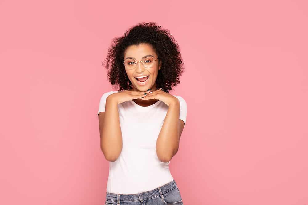 A black woman styled her curly hair with old argan oil and other expired hair products.