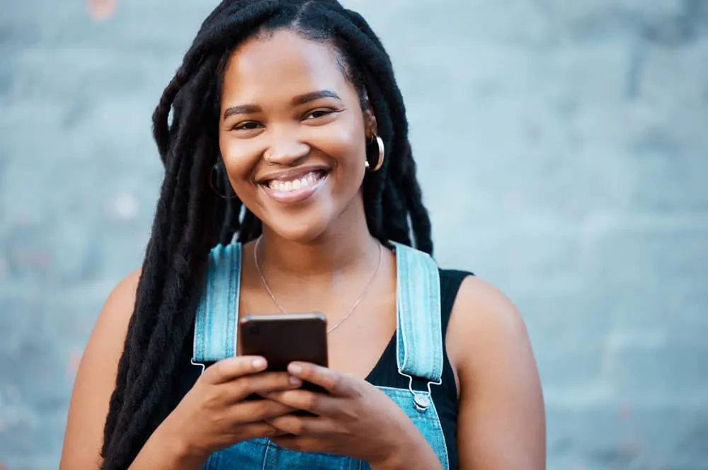 How Long Does It Take 4C Hair to Loc up With 4C Loc Phases 1 A black woman with long hair wearing adult-stage instant locs with minimal-frizz on her 4C hair type.