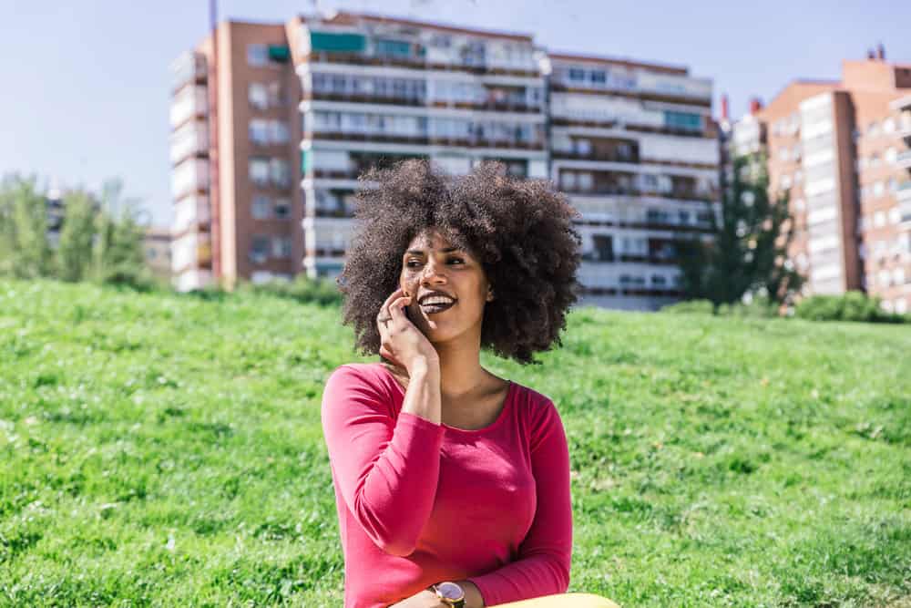 A pretty woman is waiting outside for her salon appointment with more hair after using lemon oil for hair growth.