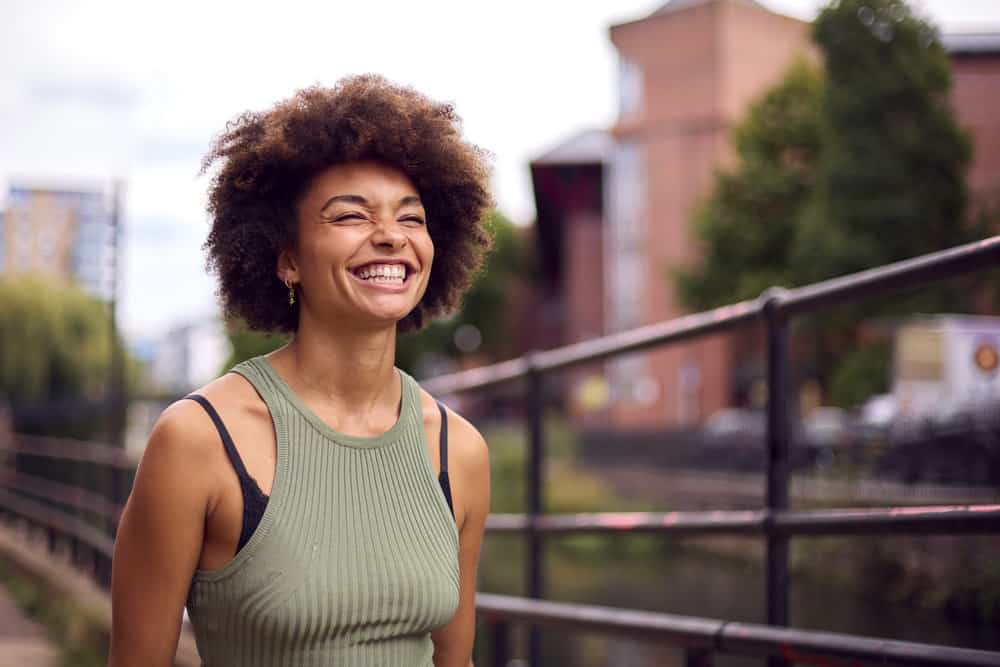 A black girl uses a scalp massage device for increased hair thickness and to reduce hair loss.